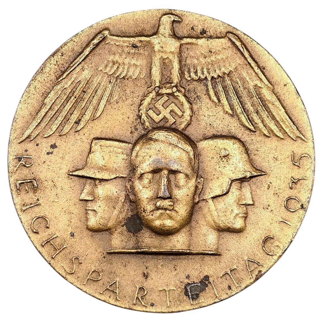 NSDAP Reichsparteitag 1935 Badge: A pin-back badge commemorating the 1935 Reichsparteitag, depicting a Party eagle atop a wreathed swastika above a set of profile heads flanked by the inscription "REICHSPARTEITAG 1935." Made of a meta