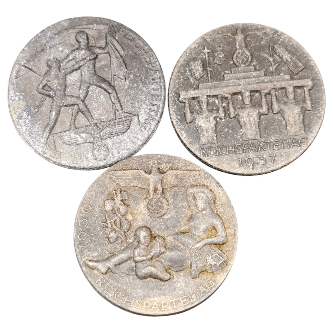 Nazi Third Reich Tinnie Event Badges: A set of pin-back membership/event badges (tinnies) commemorating the Reichsparteitag (Nazi Party Rally Day), dated 1937 and 1939 respectively on two examples, the third undated but of the same series