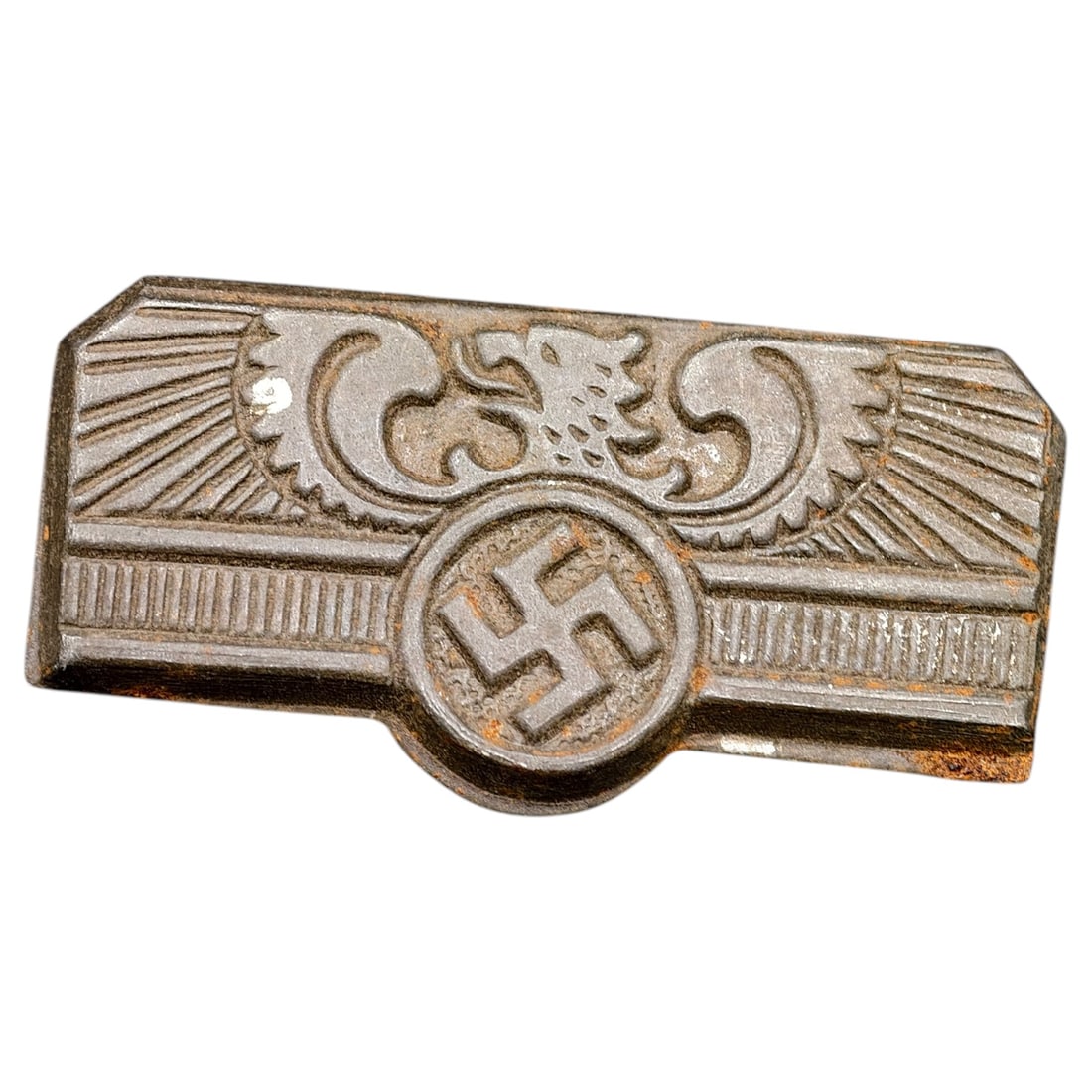 Third Reich Nazi Tinnie Badge: A cast metal pin-back badge featuring a stylized eagle with wings above a central swastika roundel, flanked by ray/sunburst motifs. The reverse retains remnants of a fabric or paper backing. No maker 