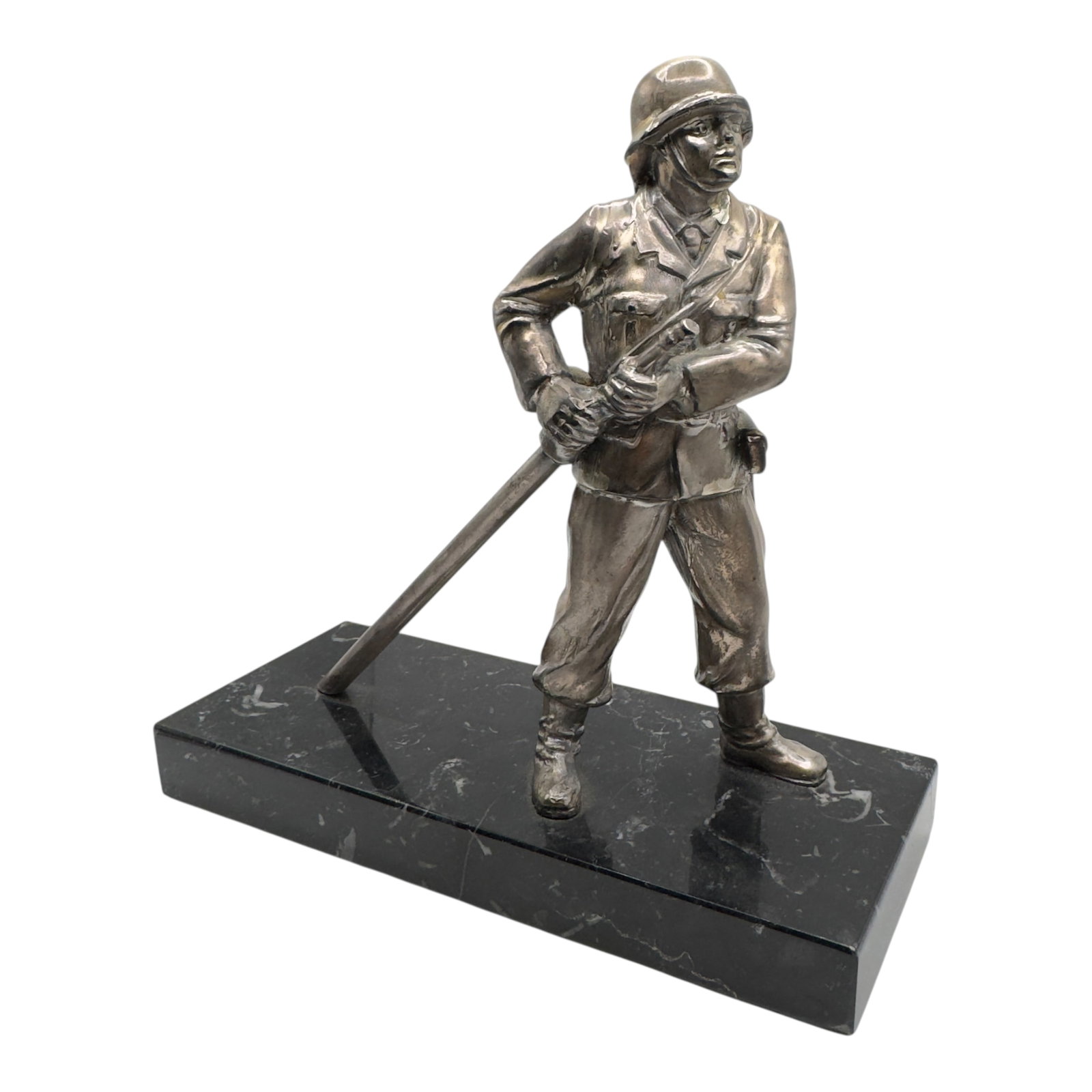 Third Reich Fire Brigade Desk Ornament: A metal figure with a finish in what appears to be silver, of a helmeted fireman in uniform holding a fire axe/pike, mounted on a black marble base. The figure appears cast in a heavy metal with a fin