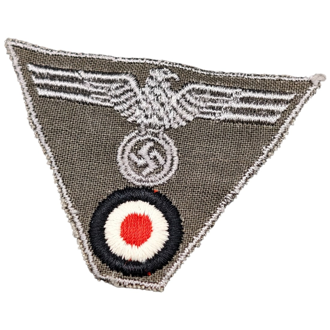 Nazi Trapezoid Cap Eagle Cockage Insignia: A machine-embroidered bevo-style trapezoid insignia for the M43 field cap, combining the Wehrmacht Heer eagle clutching a mobile swastika above a national cockade in red, white, and black. Woven in th
