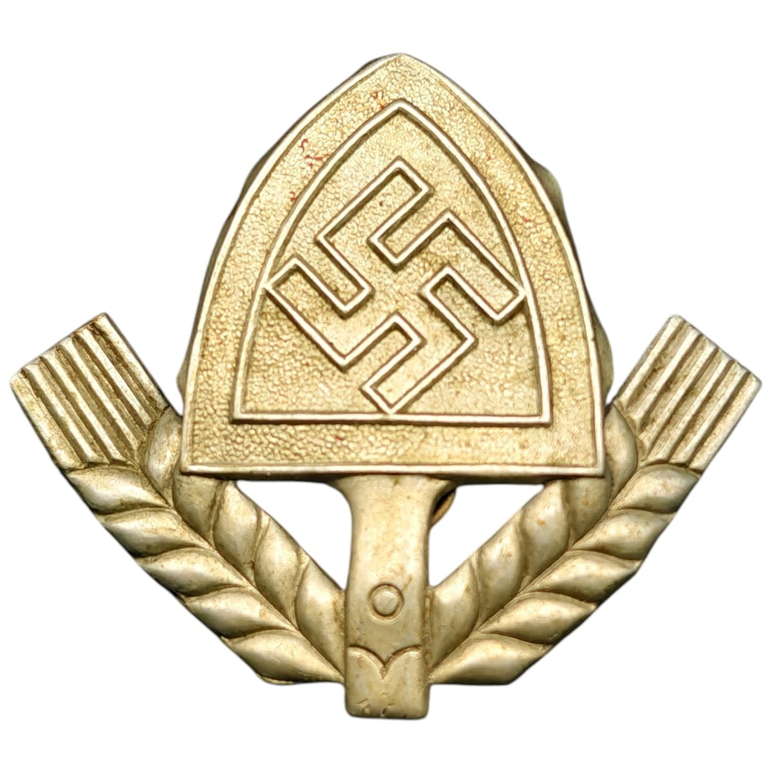 German WWII RAD Cap Badge Insignia: A cap badge featuring a shield-shaped emblem with a swastika device flanked by wheat sheaf sprigs, worn on RAD (Reichsarbeitsdienst) headgear. The badge is a stamped metal construction with a gilt-ton