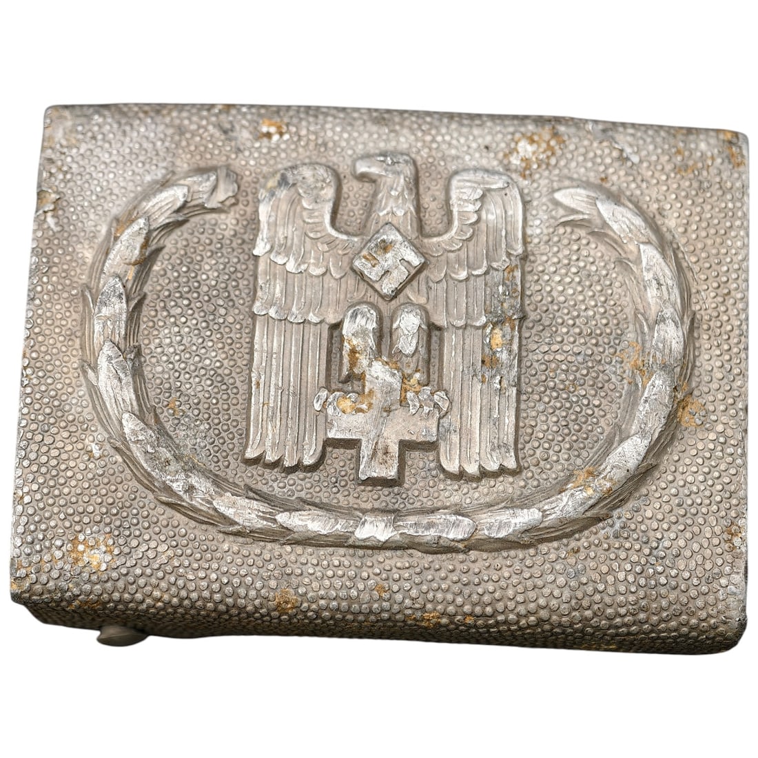Third Reich Red Cross Belt Buckle: Aluminum belt buckle featuring an eagle clutching a wreathed swastika above a Red Cross emblem, surrounded by a laurel wreath, with pebbled field texture. Reverse marked "GES.GESCH." with a manufactur