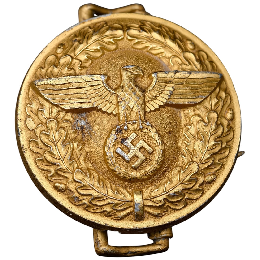 Third Reich Nazi Heer Officer Belt Buckle: A round buckle in a finish that appears to be gilt, featuring an eagle clutching a wreathed swastika, surrounded by an oak leaf wreath border, consistent with NSDAP political leader (Politische Leiter