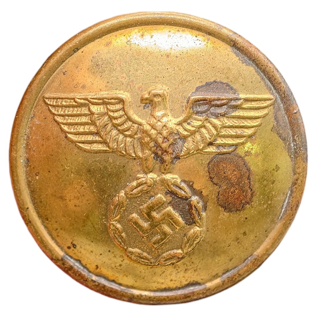 NSDAP Uniform Button: A domed button in what appears to be brass, featuring a raised German eagle with outstretched wings clutching a wreathed swastika, consistent with NSDAP party or affiliated organization uniforms. The