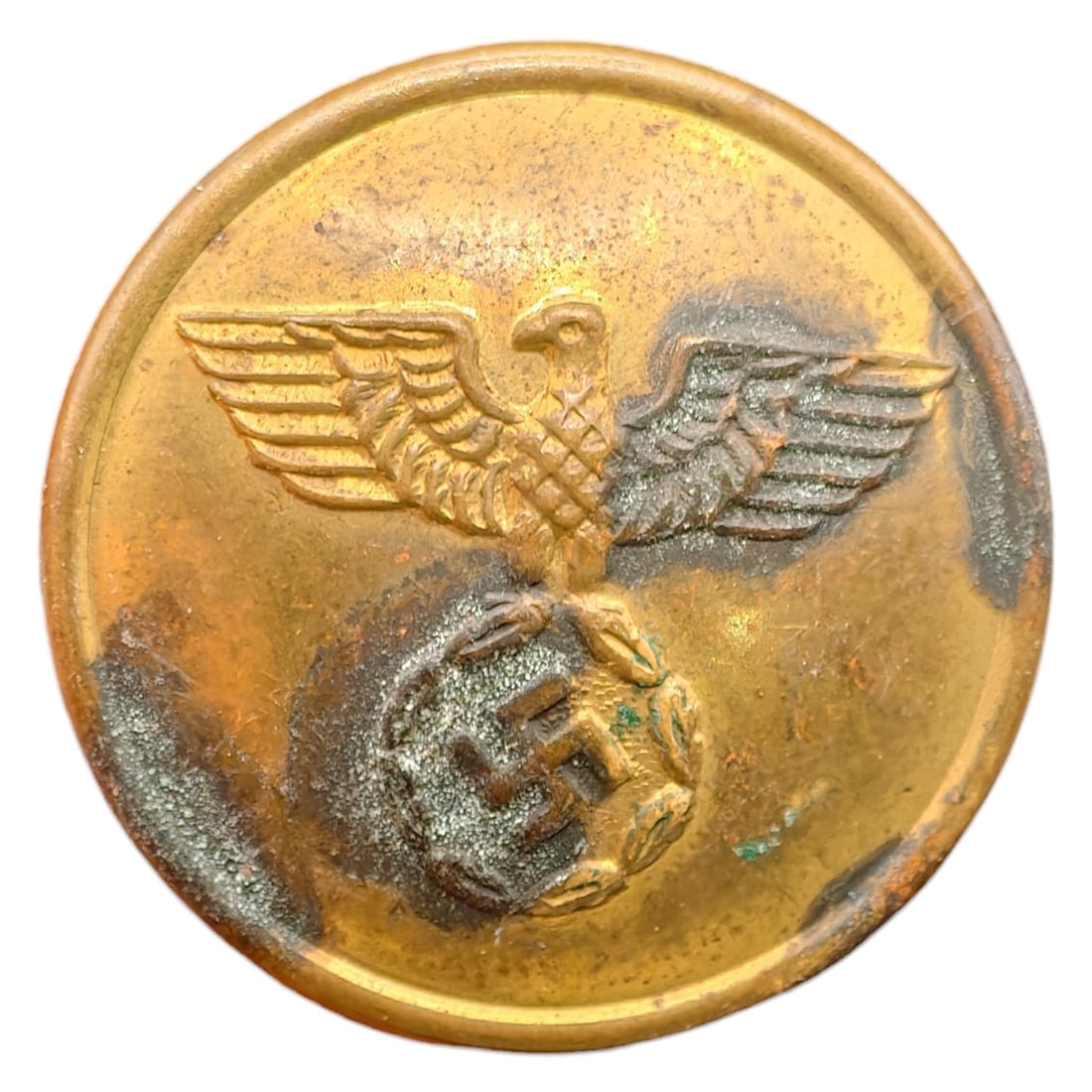 NSDAP Uniform Button: A domed button in what appears to be brass, featuring a raised German eagle with outstretched wings clutching a wreathed swastika, consistent with NSDAP party or affiliated organization uniforms. The