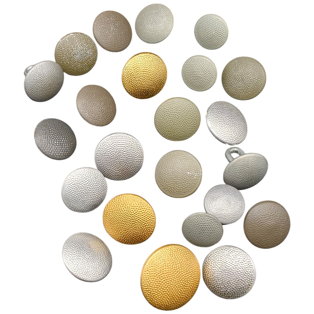 German WWII Uniform Buttons Lot - Pebbled Aluminum and Gilt Tunic Buttons: A set of domed uniform buttons with pebbled/textured faces, in what appears to be silver-tone aluminum and gilt-finish brass or brass-plated variants. Reverse sides show wire shank loops and maker mar
