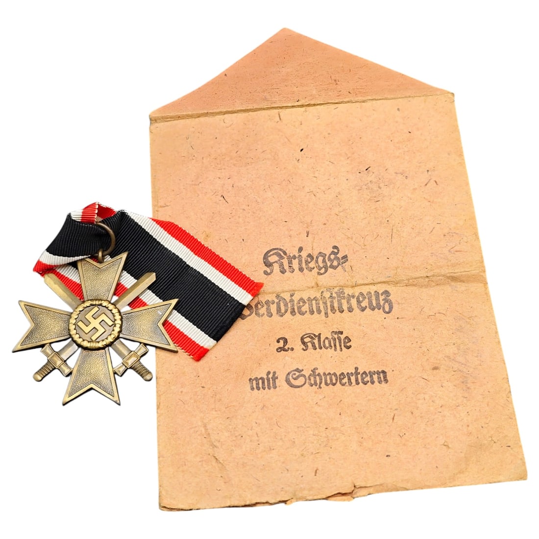 Third Reich War Merit Medal with Envelope: A War Merit Cross 2nd Class with Swords (Kriegsverdienstkreuz 2. Klasse mit Schwertern), cross in what appears to be bronze-toned metal with central swastika roundel, crossed swords, and "1939" date o
