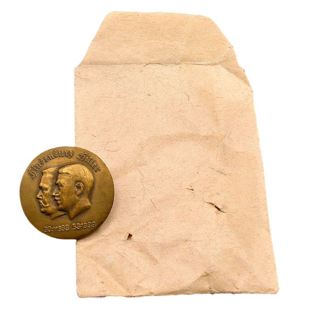 Adolf Hitler Hindenburg Commemorative Badge with Envelope: A round tinnie-style commemorative badge depicting the conjoined profiles of Paul von Hindenburg and Adolf Hitler, inscribed 'Hindenburg Hitler' above and dated '30.1.1933' and '5.3.1933' below, marki