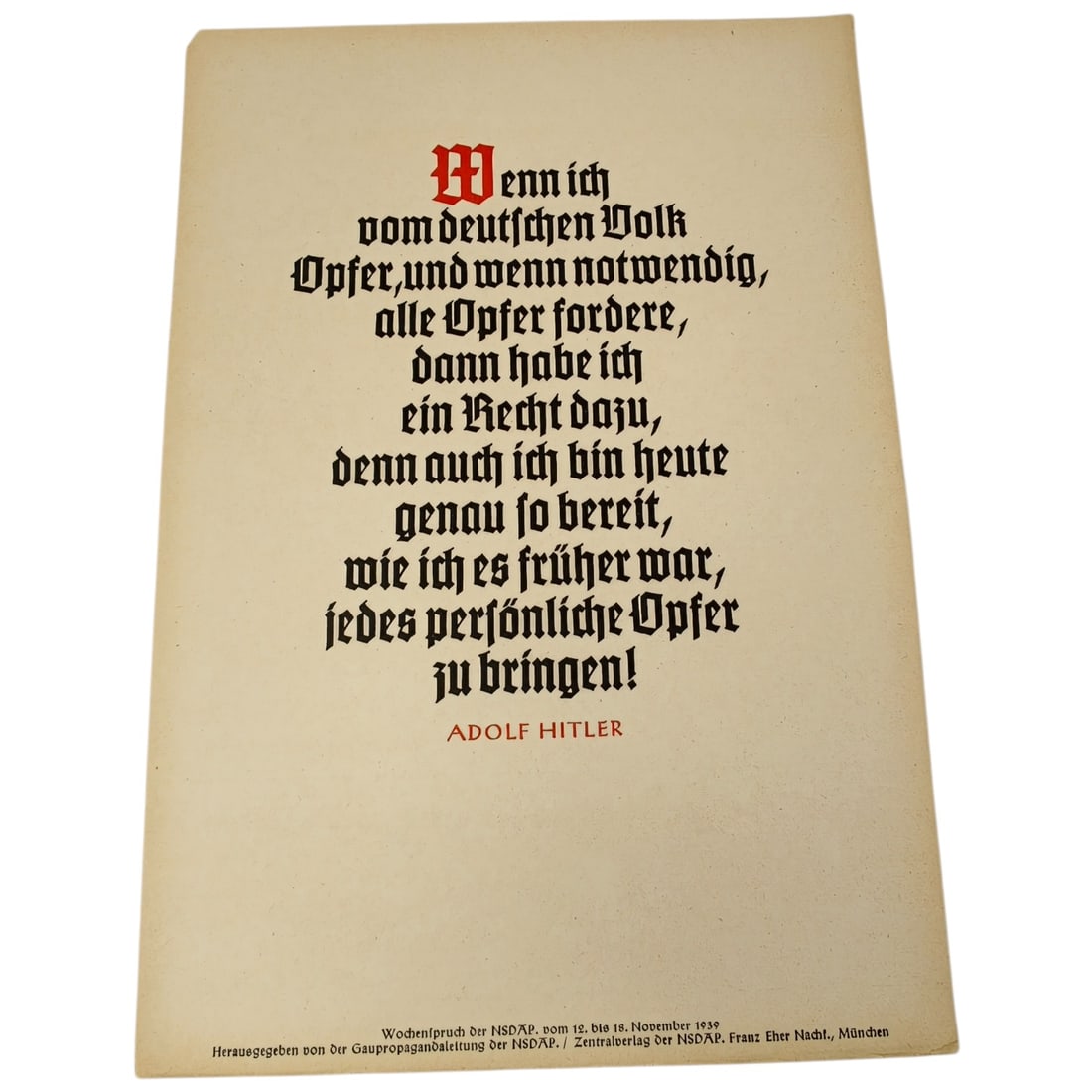 German WWII NSDAP Weekly Quote Sheet "Wochenspruch der NSDAP" (Nov 1939): Printed propaganda broadsheet featuring a quotation attributed to Adolf Hitler in Fraktur (blackletter) typeface, with initial letter and attribution printed in red. Text at lower margin identifies it
