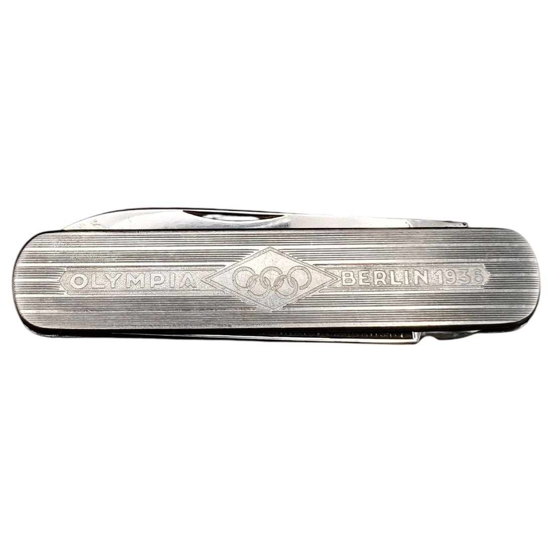 1936 Berlin Olympics Commemorative Pocket Knife "Olympia Berlin 1936": A pocket knife with a body in what appears to be nickel-silver, multi-blade, commemorating the 1936 Berlin Olympic Games. The case is engine-turned with fine linear striping and features an engraved c