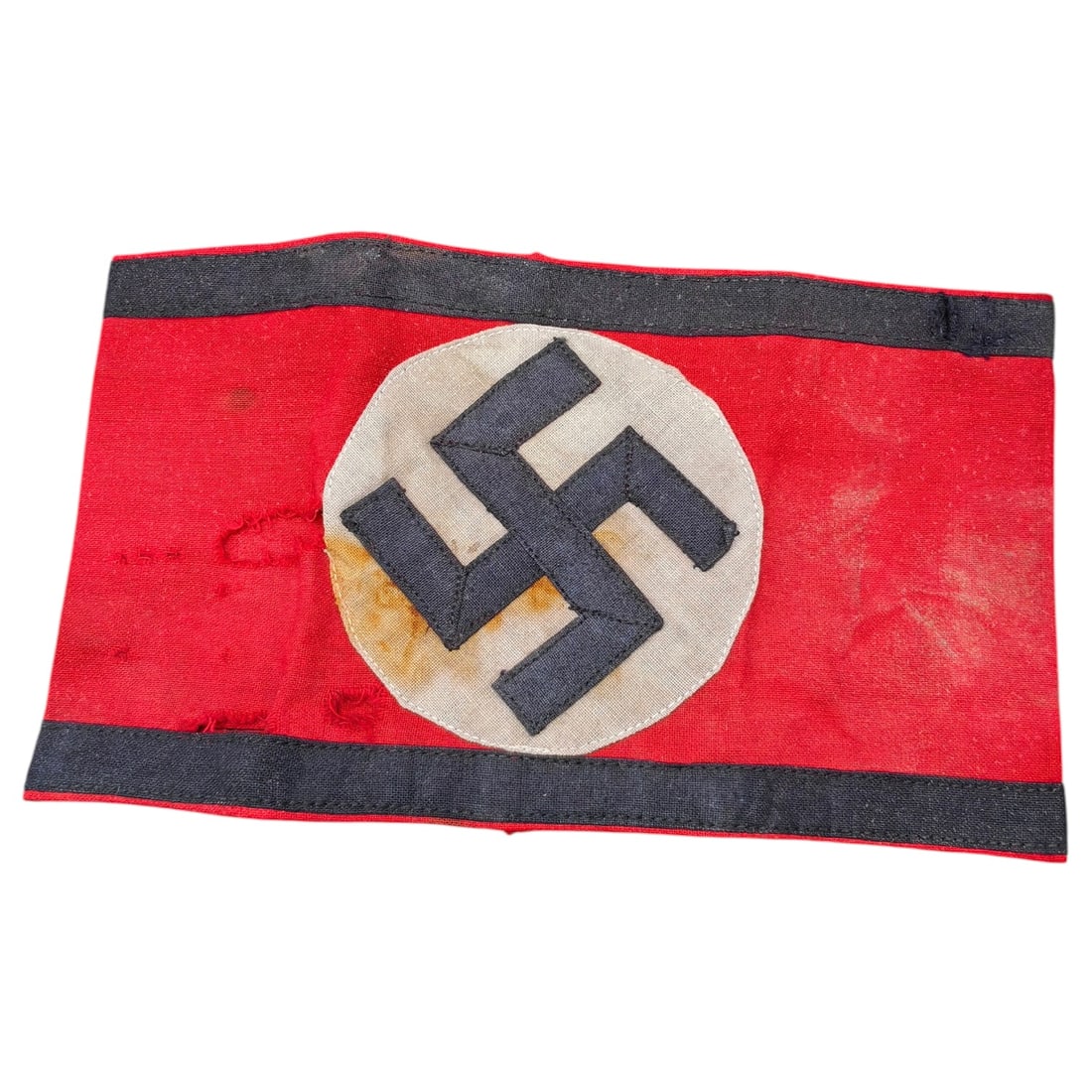 SS Armband: A period cotton SS armband in red with black stripes and a central white disc bearing a black appliquéd swastika, multi-piece construction with machine stitching.