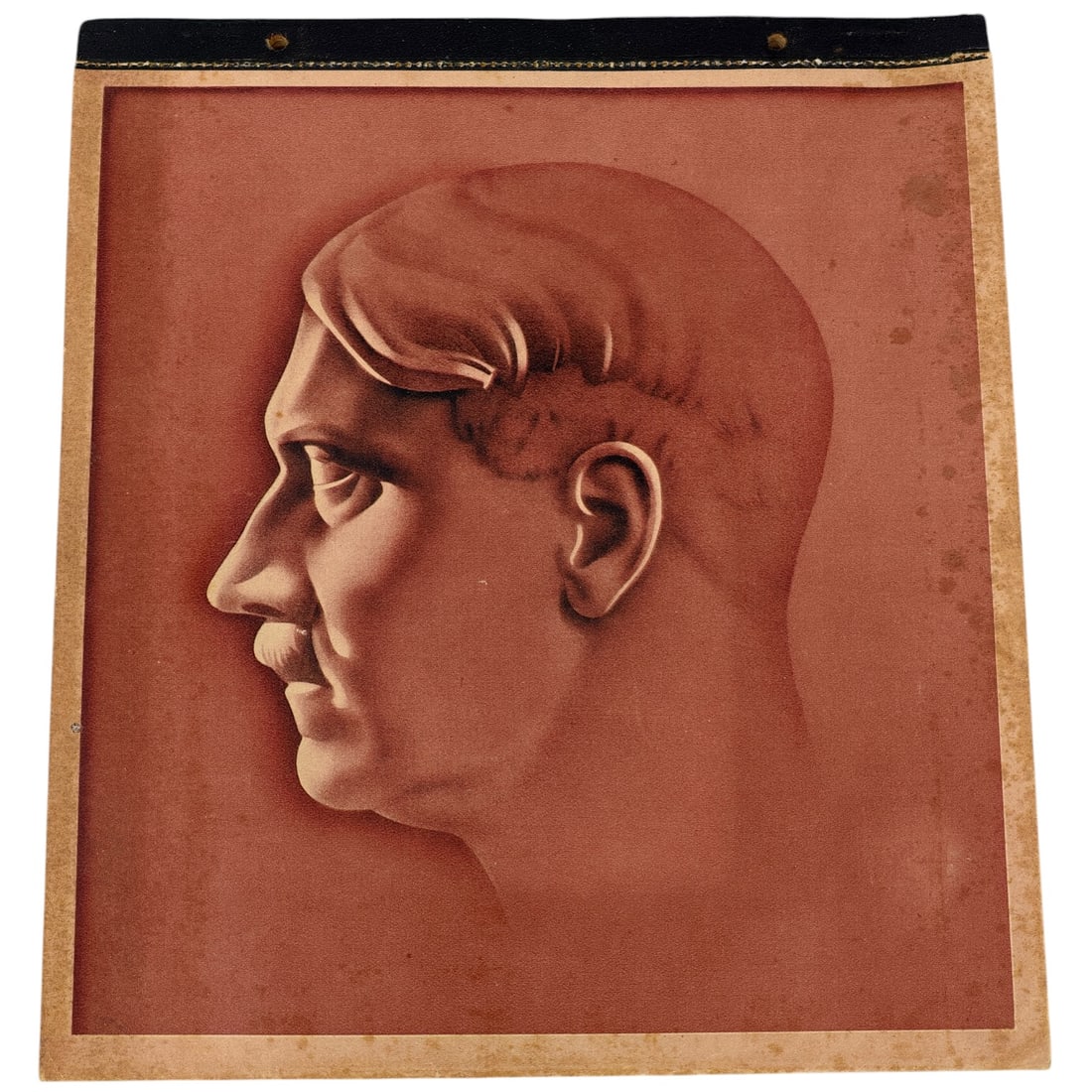 Complete Third Reich Calendar with Leaders of the Nazi Party: A monochrome sepia-toned printed image depicting a stylized male profile portrait, likely part of a larger calendar or booklet series given the black cloth-taped and grommeted top edge. The image appe