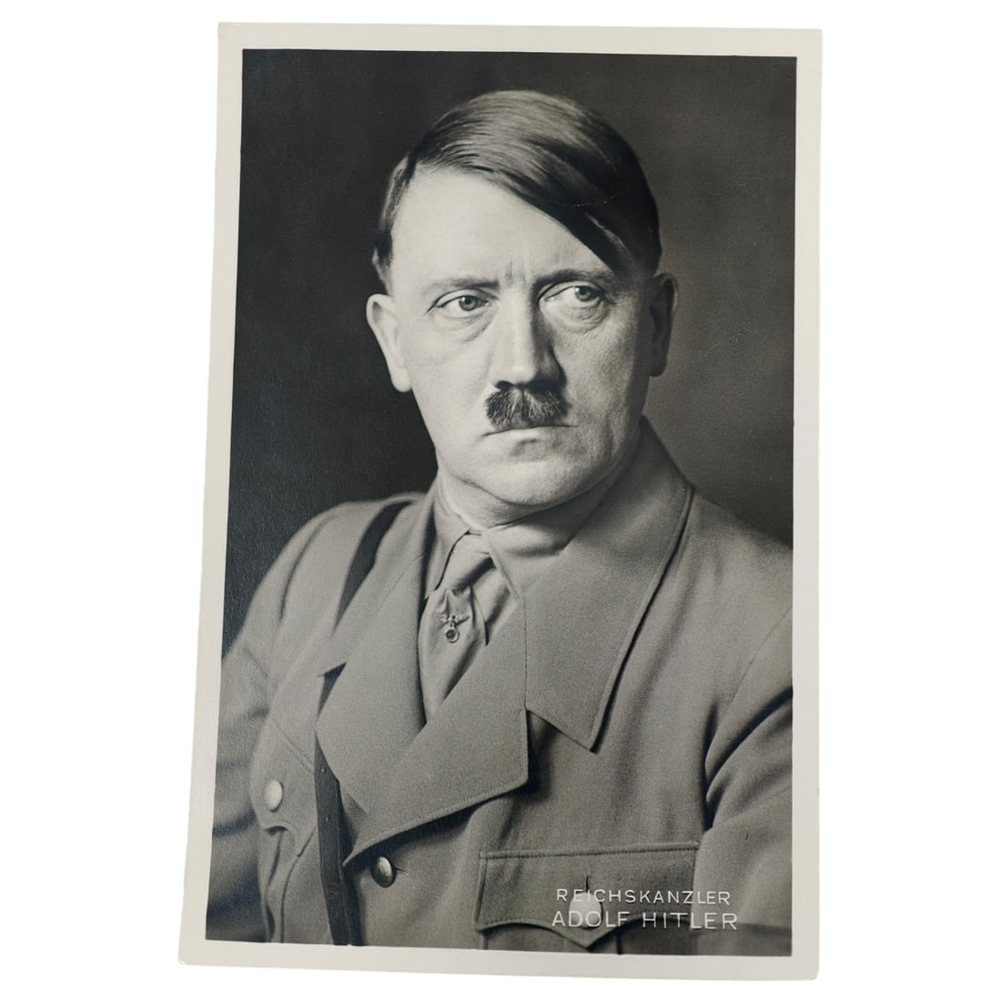 Adolf Hitler Postcard: Original period real-photo postcard portrait of Adolf Hitler as Reichskanzler, captioned in the lower right corner. Reverse marked "Photo-Hoffmann, München, Amalienstr. 25" with "Nachdruck verboten"