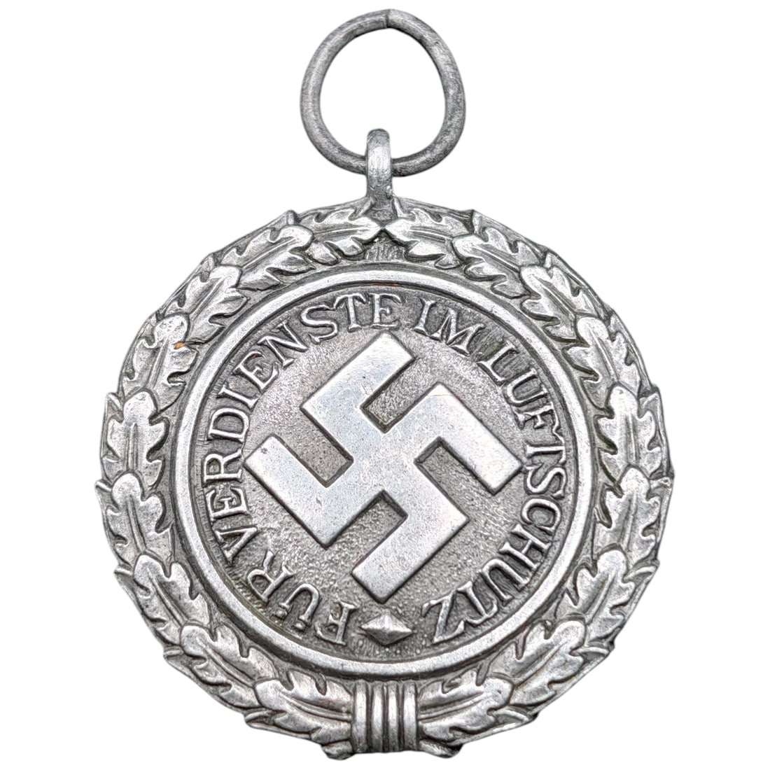 German Luftschutz (Air Protection) Service Medal, Dated 1938: A circular award medal bearing the inscription "FÜR VERDIENSTE IM LUFTSCHUTZ" (For Services in Air Protection) surrounding a central swastika, encircled by an oak leaf wreath. The reverse is simi