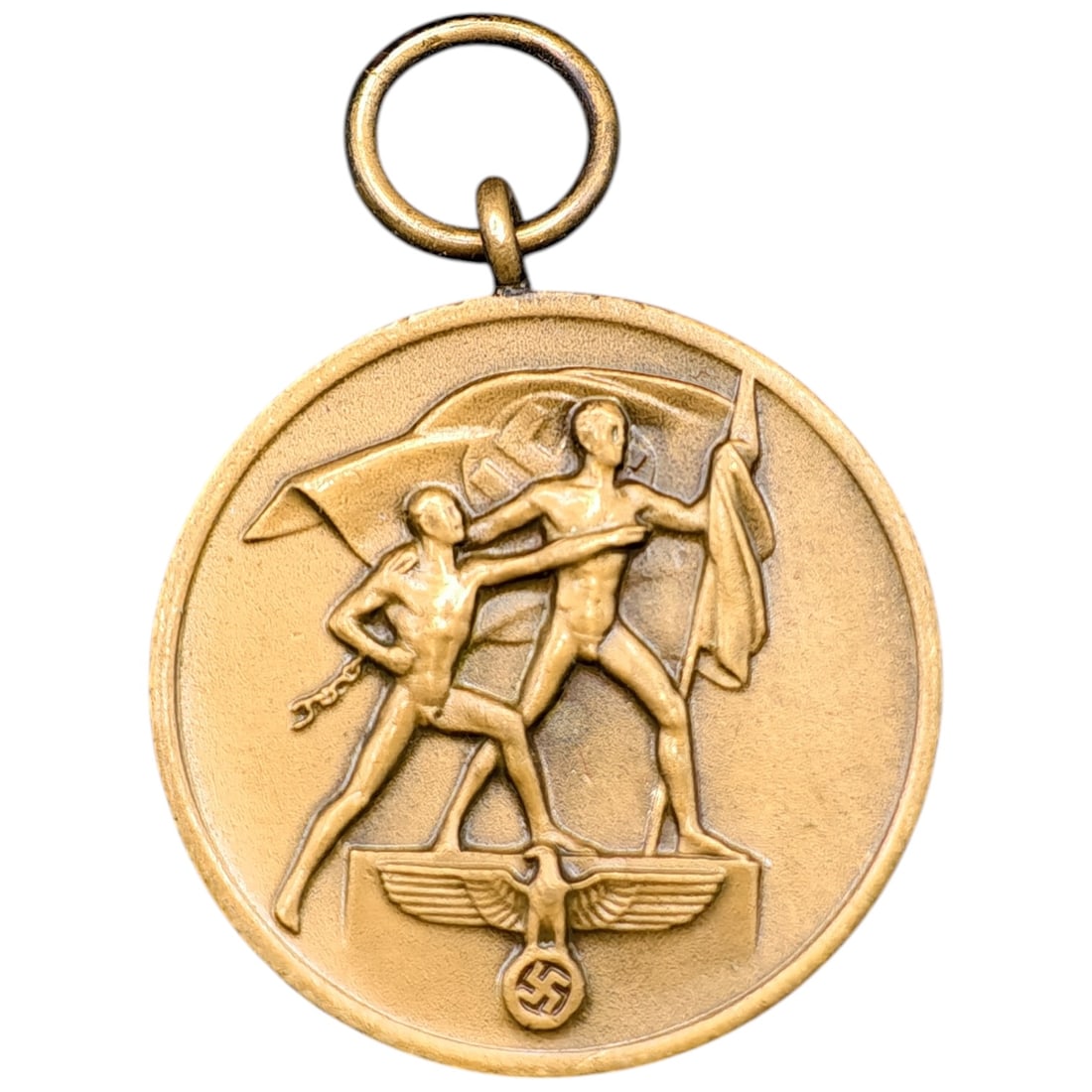 German Third Reich Sudetenland Commemorative Medal, 1. Oktober 1938: A commemorative medal issued to mark the annexation of the Sudetenland, struck in a base metal with a bright yellow-gold finish. One face depicts two male figures in classical style, one raising a fla