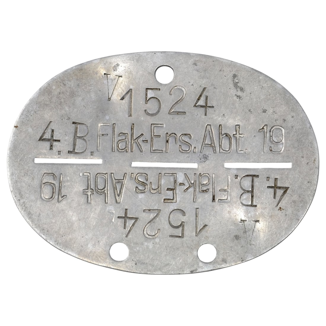 German WWII Luftwaffe Identity Disc, 4./B.Flak-Ers.Abt. 19: Oval identity disc stamped with the unit designation "4.B.Flak-Ers.Abt. 19" and the numeral "V1524", the text repeated in mirrored form below the perforation slots so the disc could be divided into tw