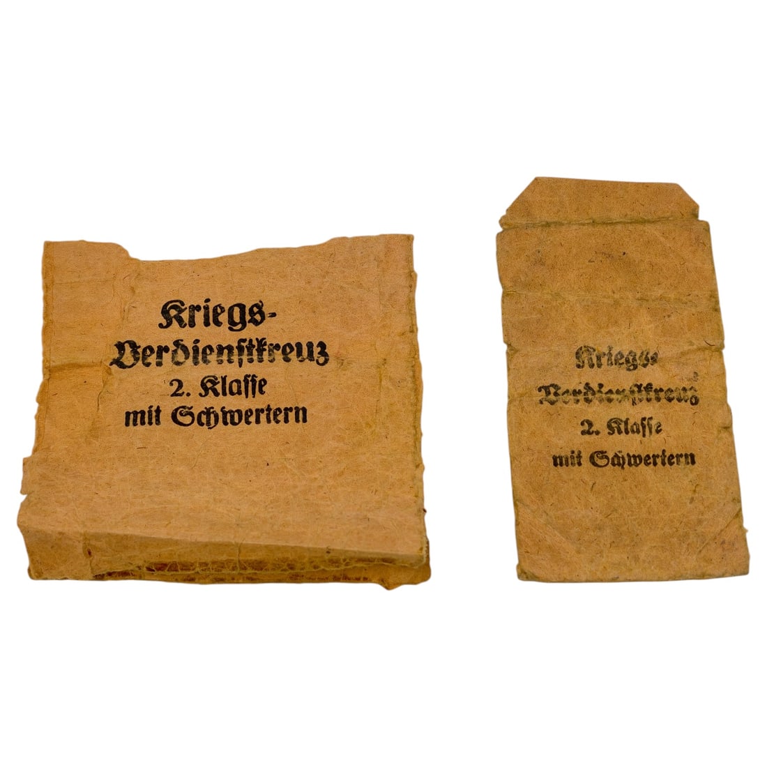 Set of German WWII Kriegsverdienstkreuz 2. Klasse mit Schwertern Paper Packets: A set of two paper issue packets printed in Fraktur script reading "Kriegs-Verdienstkreuz 2. Klasse mit Schwertern", used for the War Merit Cross 2nd Class with Swords. The smaller packet retains a ma