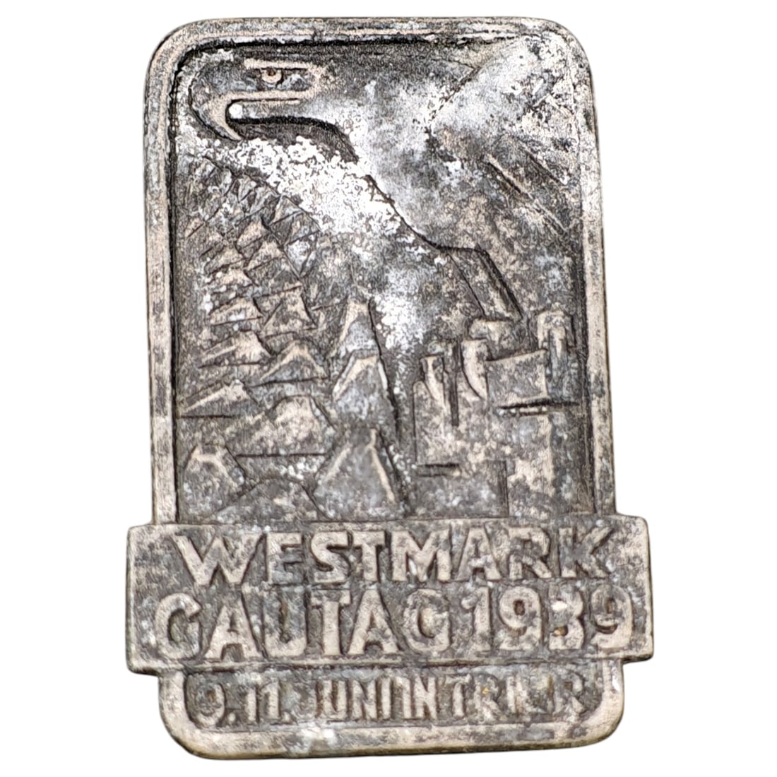 German Third Reich Westmark Gautag 1939 Tinnie Badge: A commemorative tinnie badge issued for the Westmark Gautag rally held June 10-11, 1939, marked "WESTMARK GAUTAG 1939" with the event dates below. The design depicts a stylized eagle in flight over a 