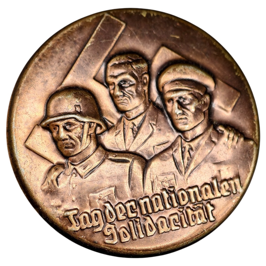 German 'Tag der nationalen Solidarität' Commemorative Badge: A round badge in what appears to be bronze, produced for the National Socialist 'Day of National Solidarity' (Tag der nationalen Solidarität), a Nazi-era Winter Relief (Winterhilfswerk) charity colle