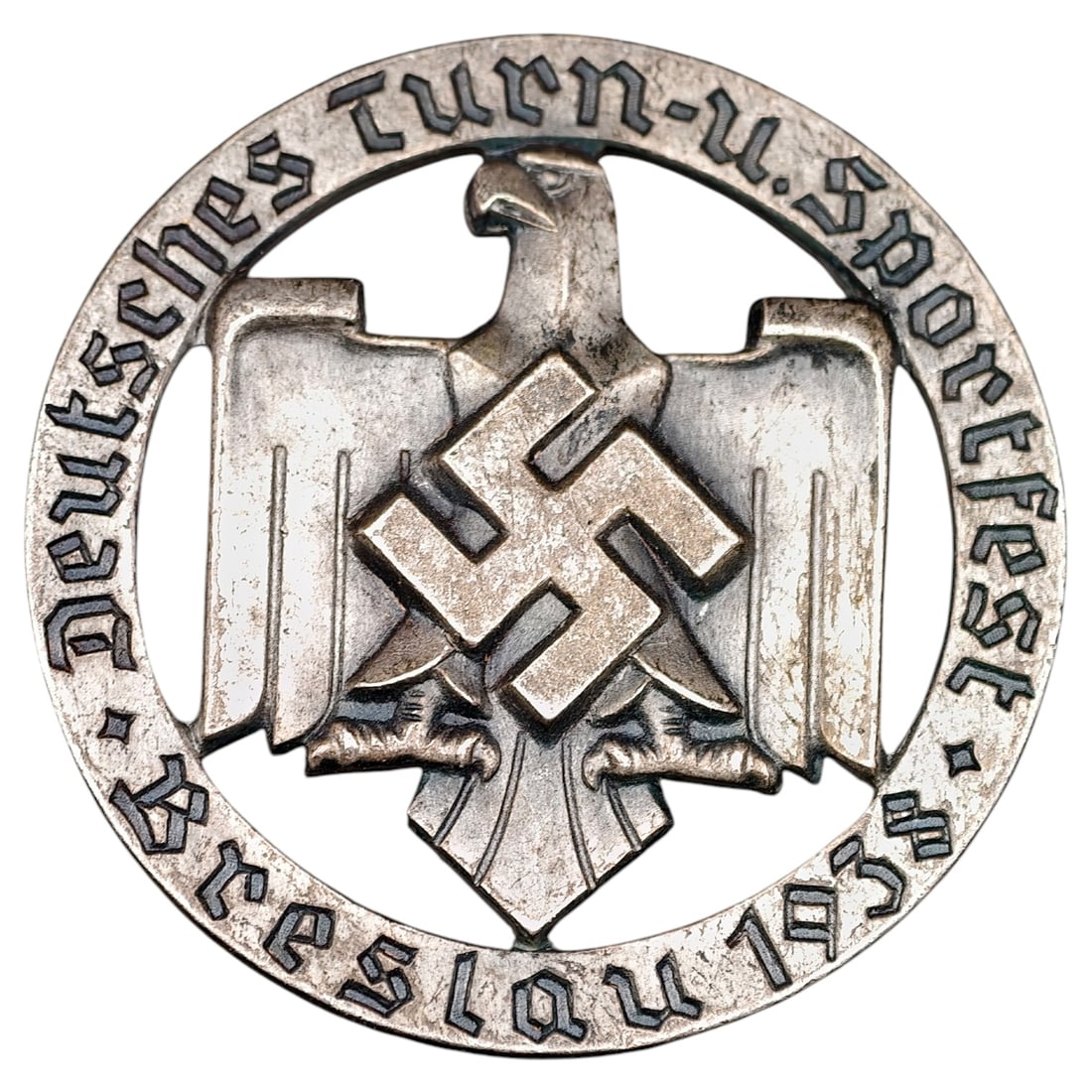 German 1938 Breslau "Deutsches Turn- u. Sportfest" Badge by Rob. Neff, Berlin: A round commemorative badge for the Deutsches Turn- und Sportfest held in Breslau in 1938, featuring an eagle grasping a wreathed swastika at center within an openwork ring inscribed "DEUTSCHES TURN-U