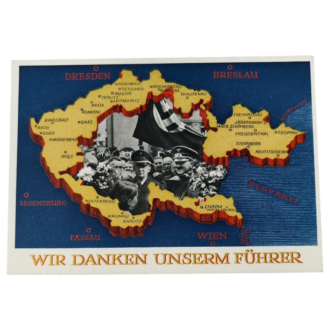 Third Reich "Wir Danken Unserm Führer" Sudetenland Commemorative Postcard, 1938: A propaganda postcard commemorating the annexation of the Sudetenland, printed with a stylized relief map of the region bordered by red-lettered city names including Dresden, Breslau, Passau, and Wien