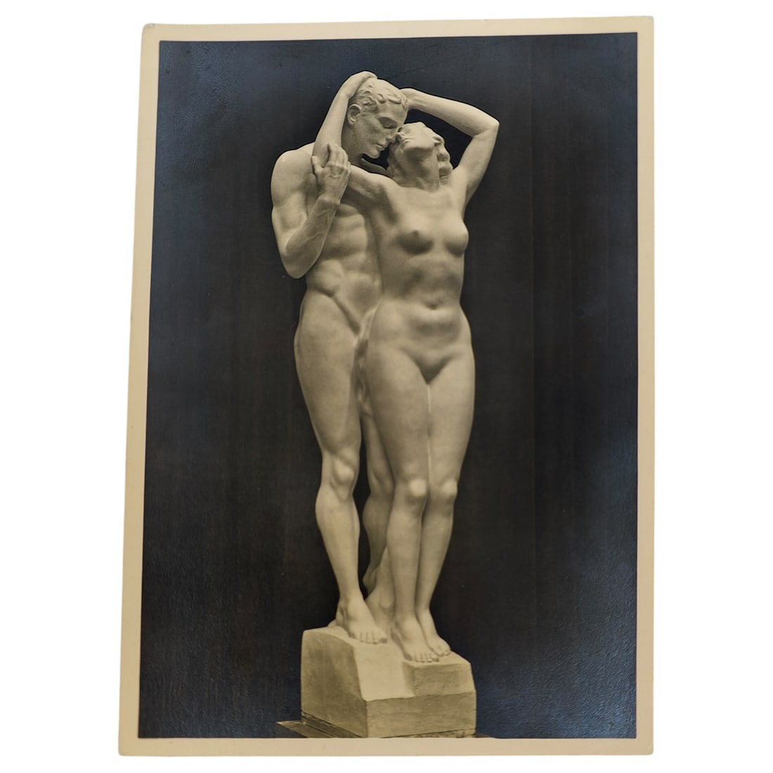 German WWII Photo Postcard "Zwei Menschen" Sculpture, Haus der Deutschen Kunst, Munich by Josef: A period photo postcard reproducing the sculpture "Zwei Menschen" (Two Humans) by Josef Thorak, depicting a standing male and female nude figure in an embrace, displayed at the Haus der Deutschen Kuns