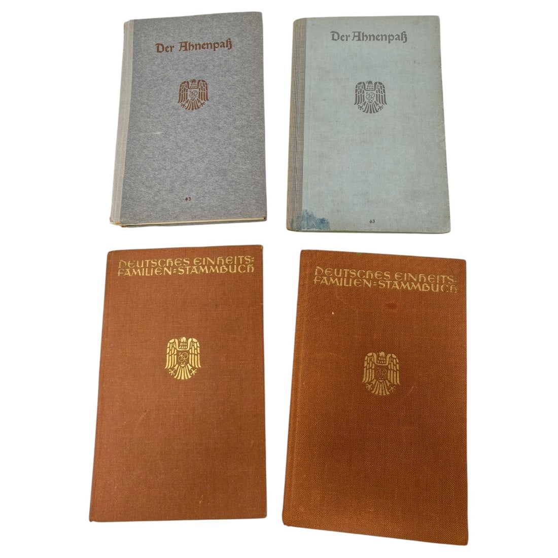 Set of German Third Reich Genealogy Books - Ahnenpaß and Familien-Stammbuch: A set of German hardcover genealogy record books from the Third Reich era, comprising two copies titled "Der Ahnenpaß" (ancestor passport) in grey and pale blue cloth covers, and two copies titled "D