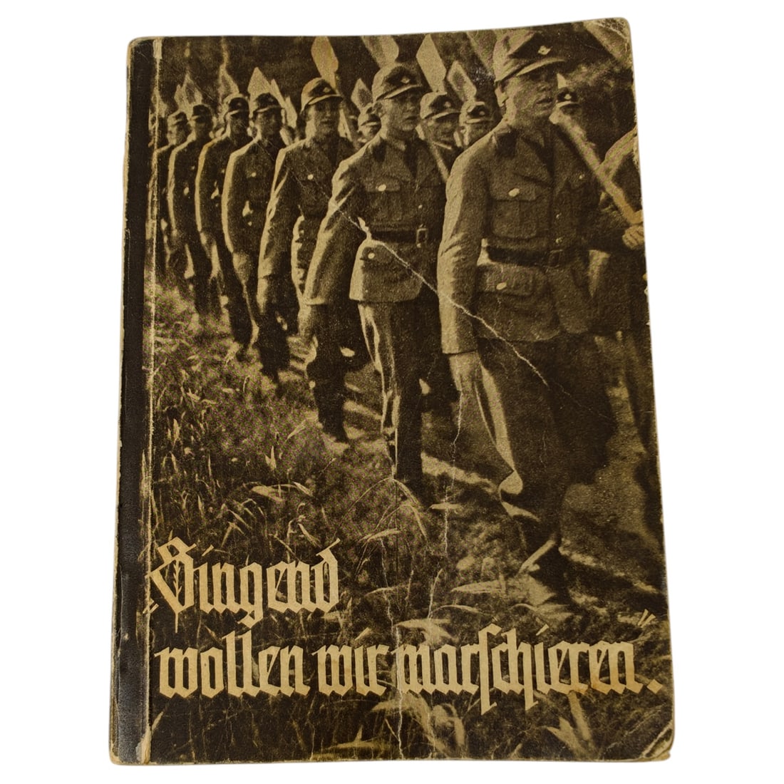 German WWII Era Softcover Book "Singend wollen wir marschieren": A softcover book titled "Singend wollen wir marschieren" ("Singing We Want to March"), the cover featuring a photographic image of uniformed men marching in formation with entrenching tools shouldered