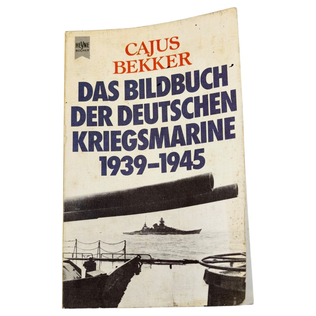 German Book "Das Bildbuch der Deutschen Kriegsmarine 1939-1945" by Cajus Bekker: A softcover pictorial history of the German Kriegsmarine covering the period 1939 to 1945, authored by Cajus Bekker and published by Heyne Bücher. The cover features a photographic image of a warship