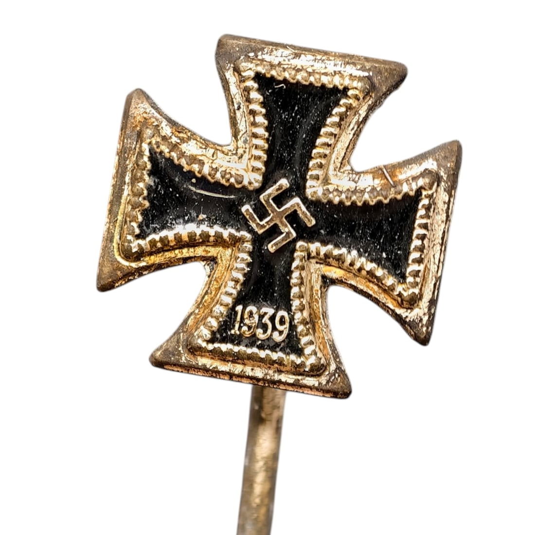 German WWII Iron Cross 1939 Miniature Stickpin: A miniature stickpin in the form of the Iron Cross, with a cross pattée body finished in black enamel bordered by a beaded metal edge that appears to be gilded. The central field bears a mobile emble