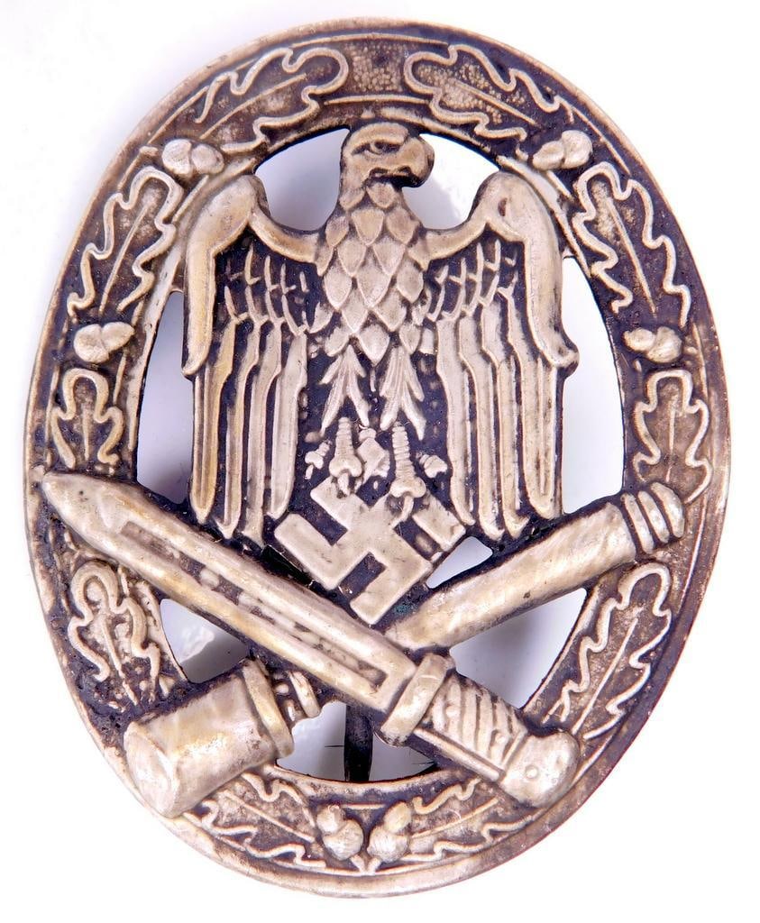 German WWII Army General Assault Badge: Die struck stamped nickel construction. Front shows a German eagle clutching a swastika in his talons in the center with a crossed bayonet and potato masher stick grenade at the base. All three are su