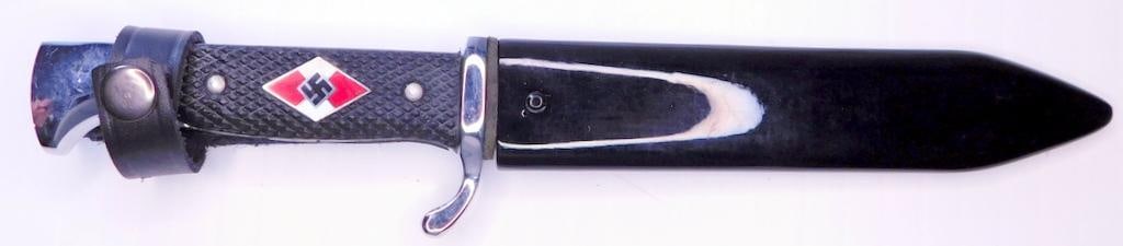 German WWII Hitler Youth HJ Knife and Scabbard: Front of the steel blade reads Blut und Ehre! (Blood and Honor!). It is maker marked Anton Wiggen Jr Solingen on the back side. It shows their Knight logo in the center and measures 1 inch wide by 5 3