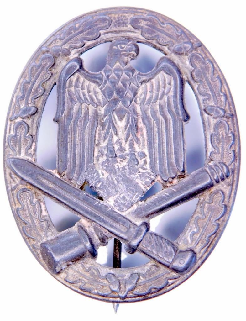 German WWII Army Silver General Assault Badge: Die struck nickel construction. Front shows a German eagle clutching a swastika in his talons in the center with a crossed bayonet and potato masher stick grenade at the base. All three are surrounded