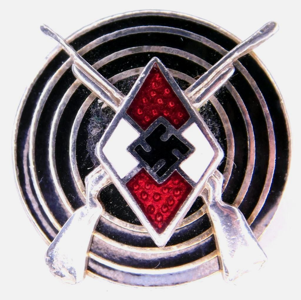 German WWII Silver Hitler Youth HJ Marksman Shooting Badge: Front shows the Hitler Youth diamond with a pair of crossed rifles behind. Both are mounted onto the front of a bulls eye in the center. Reverse side is maker marked RZM M1/14. Thin horizontal safety