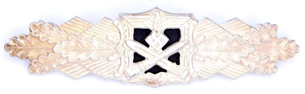 German WWII Army Silver Close Combat Clasp: Scarce. Excellent condition. Nickel construction. The front has a German eagle clutching a swastika in his talons at the top with a cross bayonet and stick grenade below. All three are flanked by oak 