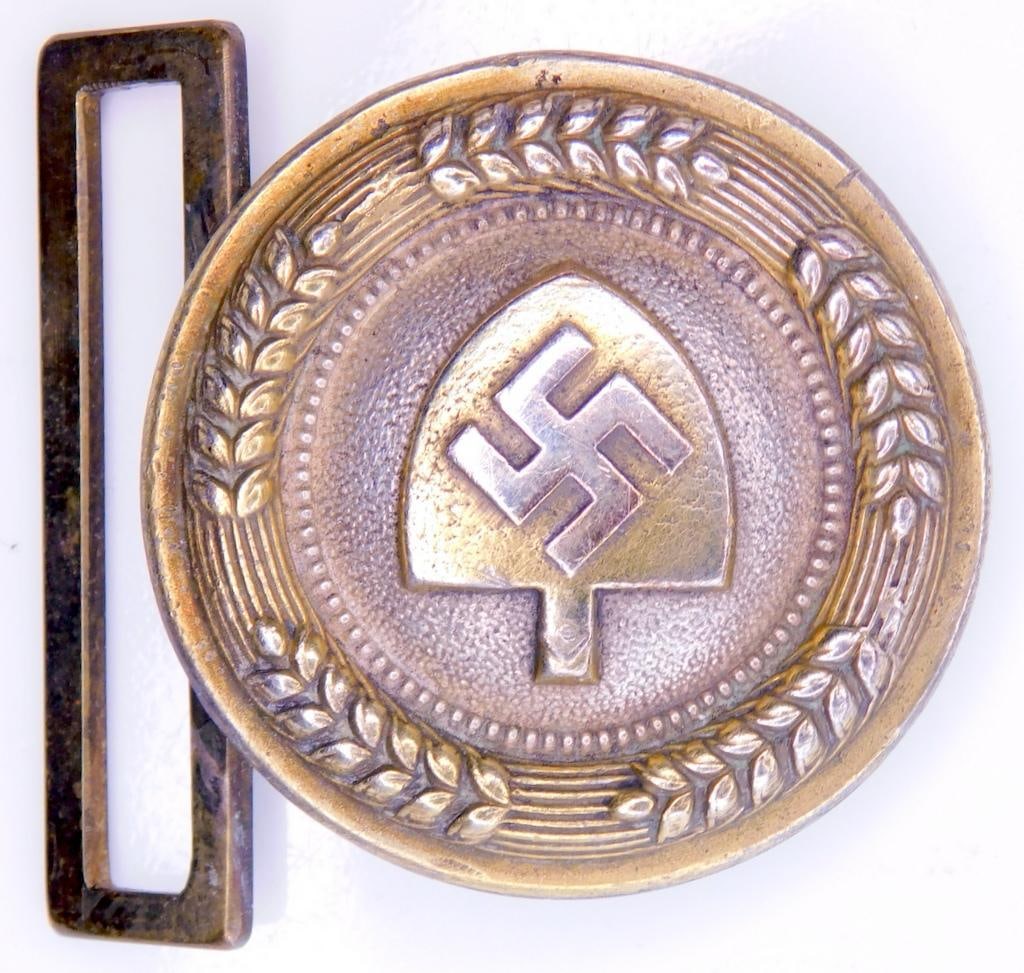 German WWII RAD Labor Korps Officers Belt Buckle: One piece die struck nickel construction. Front shows a shovel head with a swastika in the center. Both are surrounded by wheat stocks around the edge of the round belt buckle. Reverse side appears to