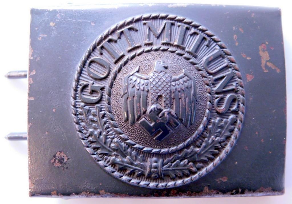 German WWII Army Enlisted Mans Belt Buckle: One piece die struck stamped green painted steel construction. Front shows a German eagle clutching a swastika in his talons. It reads Gott Mit Uns (God With Us). Reverse side is maker marked ESL 41. 