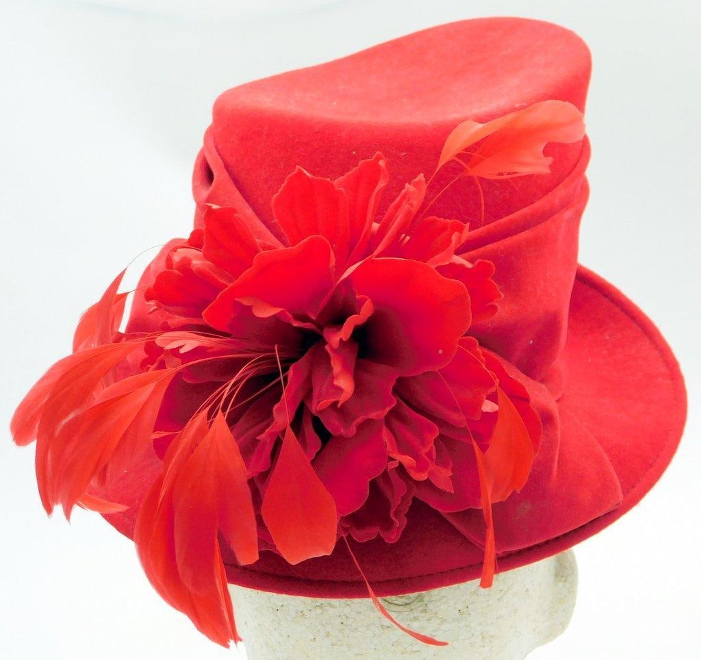 Plaza Suite New York Red Felt Hat w/ Floral Accent: Plaza Suite New York red felt hat featuring feather accent on the side Hat has a rounded crown and a curved brim, with pleated details along the base Interior is lined with red satin and displays the 