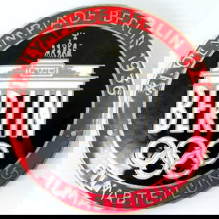1936 Berlin Summer Olympics Film Maker Badge: Front reads XI. Olympiade Berlin 1936 Filmabteilung Berlin. Shows the Brandenburg Gate with the five Olympic rings in the center. Reverse is maker-marked Rob Neff Berlin W 57. Thin horizontal safety