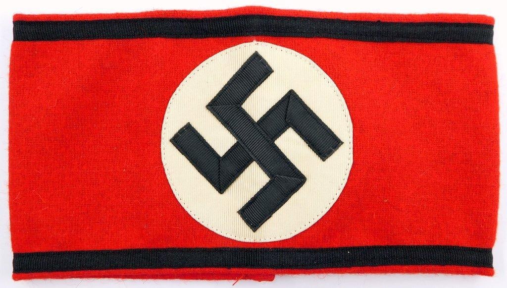 German WWII Waffen SS Shultz Staffel Swastika Arm Band: Multi-piece machine sewn wool and cotton construction. Front shows a swastika in the center of a white circle on a red rectangular background. Black strip along the top and the bottom borders. Two mac