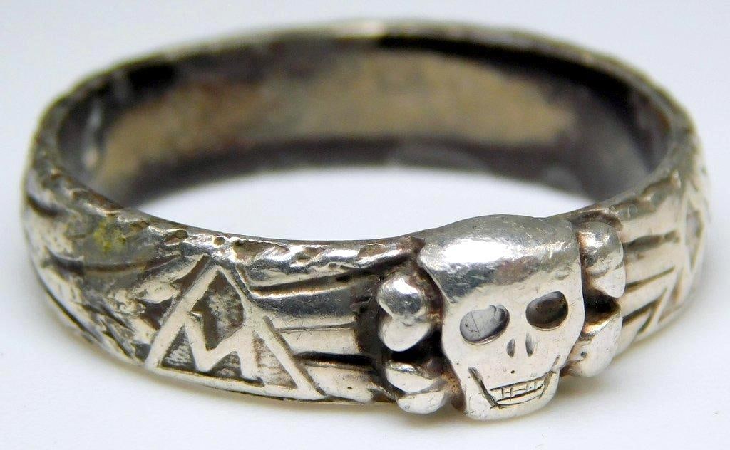 German WWII Waffen SS Officers Skull Totenkopf Honor Ring: Front shows a skull with SS runics and other emblems around the edge. Silver construction. Size 11.