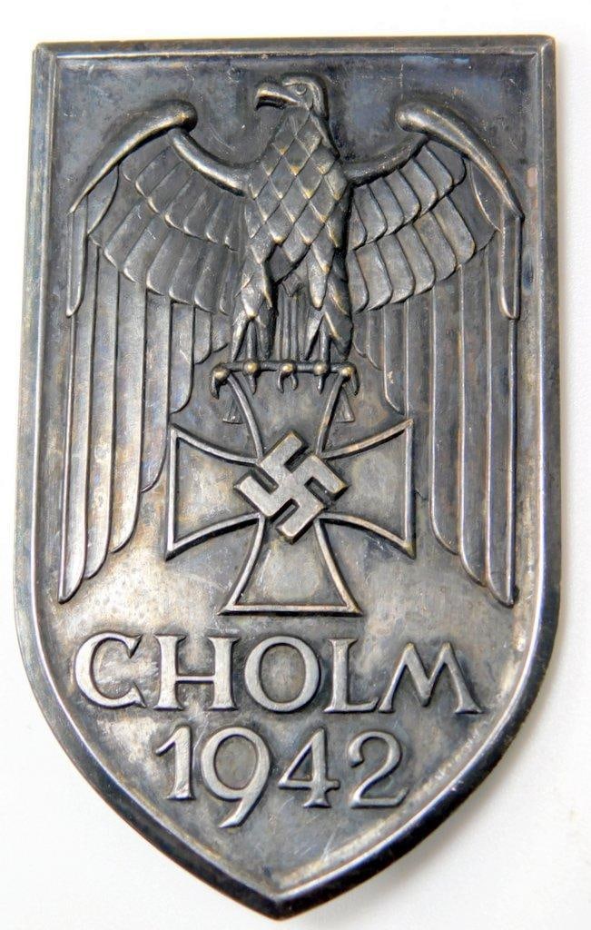 German WWII Army CHOLM 1942 Sleeve Shield: One-piece stamped nickel construction. This was to have been worn on the upper left sleeve of the uniform. Excellent condition. Front shows a German eagle clutching an Iron Cross in his talons with sw