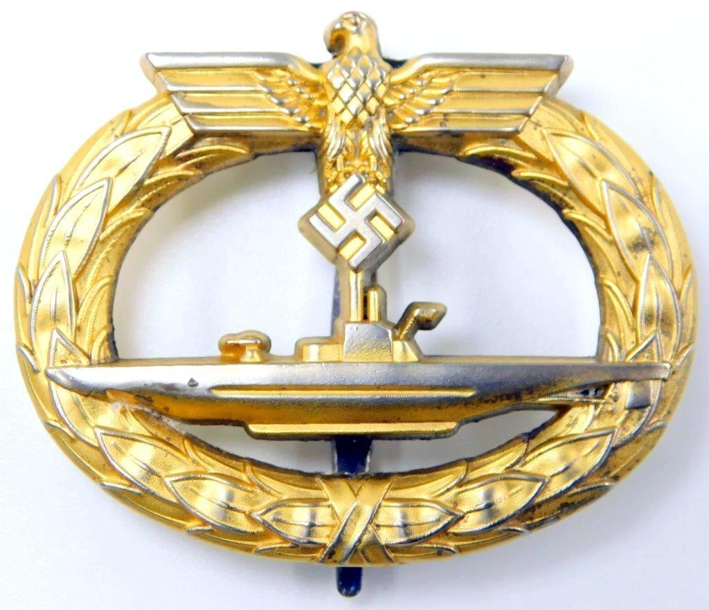 Naval Kriegsmarine U-Boat Submarine Badge: One-piece die-struck brass construction. Front shows the profile of a submarine in the center with a German eagle clutching a swastika in his talons at the top. Both are surrounded by an oval oak leaf