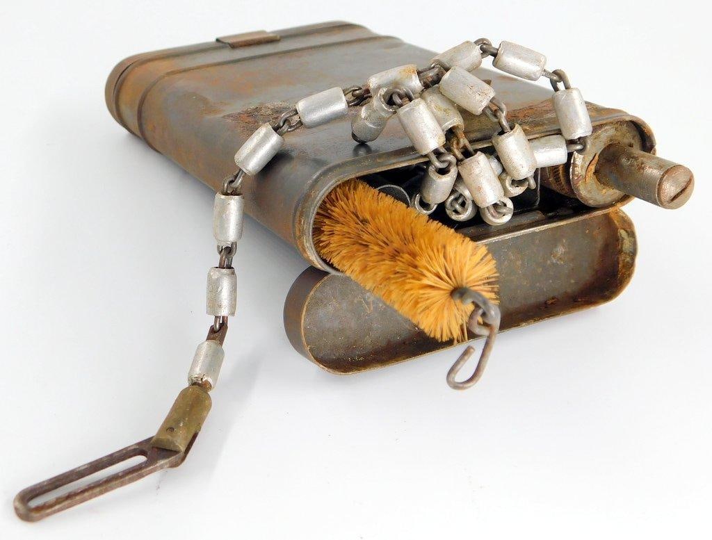 German WWII Mauser K-98 Combat Rifle Cleaning Kit: Includes the contents as shown. Metal construction. Shows use, wear, and a rust spot. Measures 3 1/4 inches wide by 5 3/8 inches tall by 7/8 inches deep.