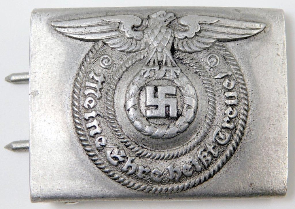 Waffen SS Schutz Staffel EM Belt Buckle: Aluminum construction. Front shows a Waffen SS eagle clutching a swastika in his talons in the center. Reads Meine Ehre heist Treue! (My Honor is Loyalty!). Reverse is maker marked RZM 36/38 SS. Inclu