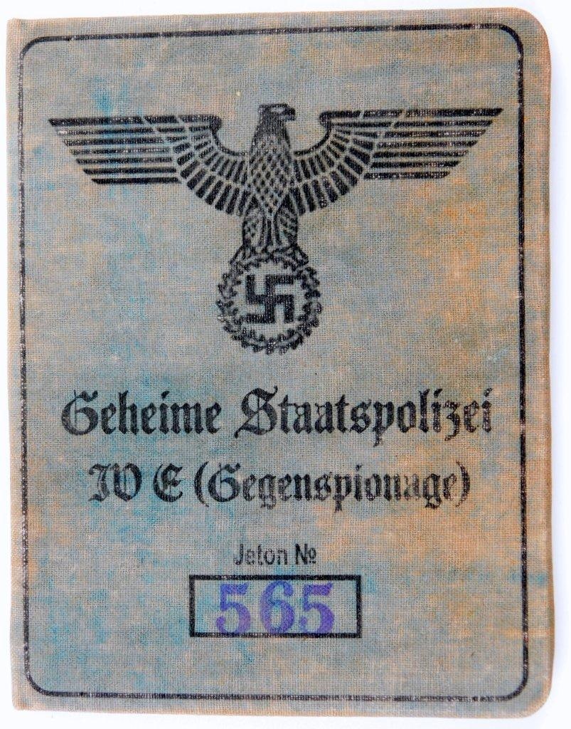 German WWII Waffen SS Officer Geheime Staatspolizei Identification Booklet: Front cover reads Geheime Staatspolizei JVE (Gegenspionage) Jeton No 565. German eagle clutching a swastika at the top. Inside has a photograph of the Waffen SS officer wearing his uniform. It also li