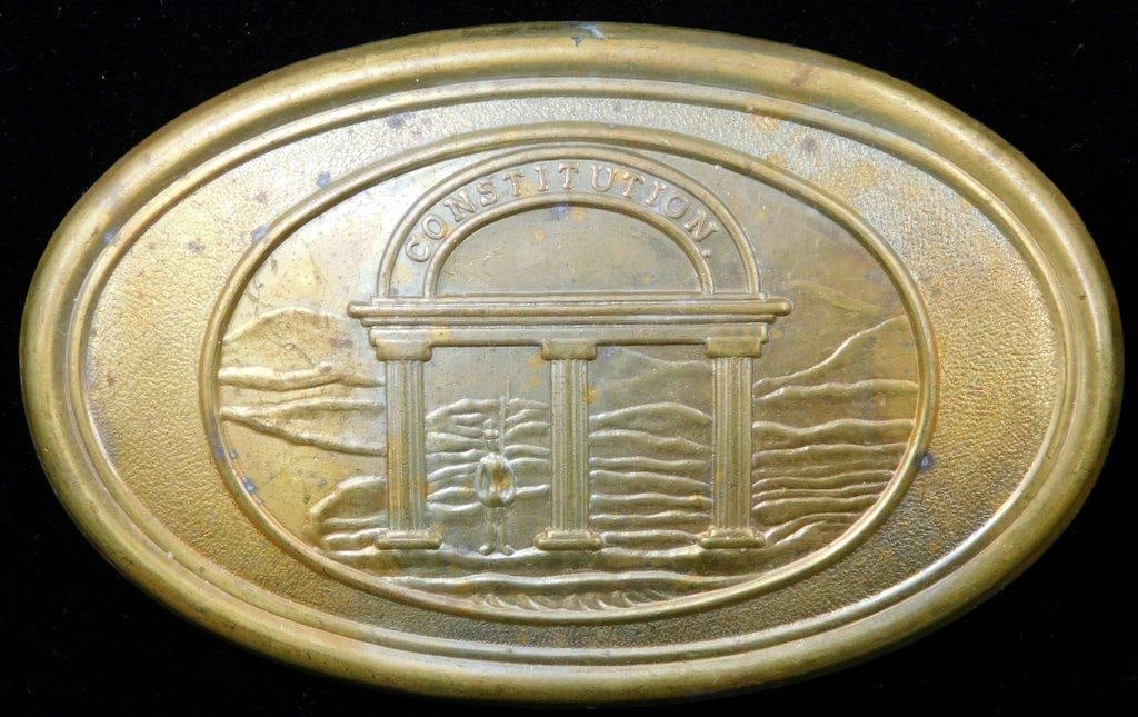 Confederate States Army CSA Georgia EM Belt Buckle: One-piece die-struck stamped brass construction with a lead filled back. For an enlisted man. Front shows three pillars with a soldier holding a rifle standing beside. Reads Constitution. Three horizo