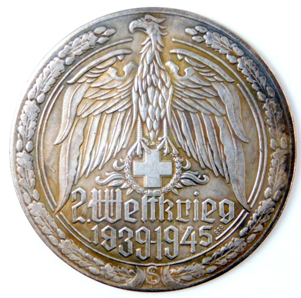 2. Weltkrieg 1939 - 1945 STALINGRAD Table Medal: One-piece die-struck nickel construction. Front shows a spread-winged eagle clutching a Red Cross in his talons. Reads 2. Weltkrieg 1939 1945. Reverse shows soldiers in the center with a German eagle 