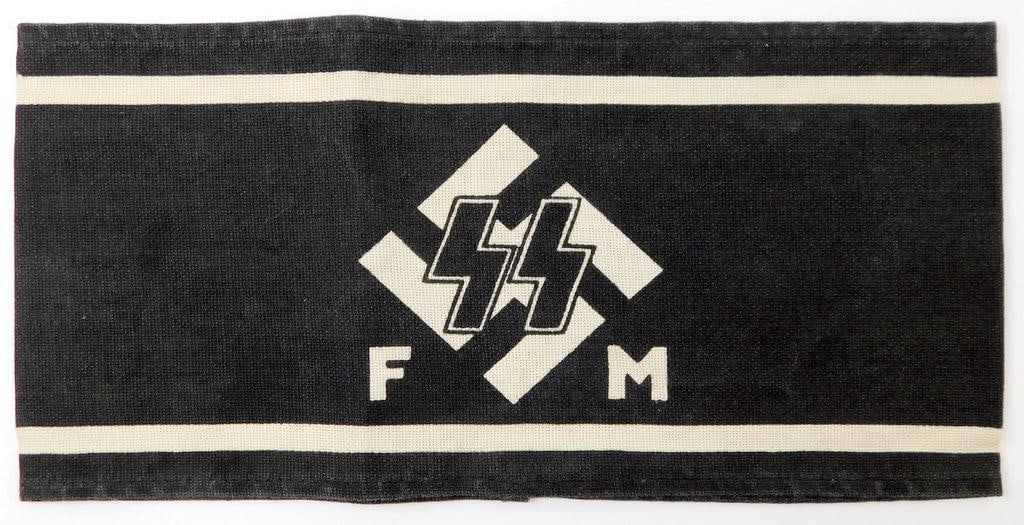 Waffen SS FM Swastika Arm Band: One-piece machine sewn printed cotton construction. Front shows a pair of SS runics with a swastika in the background in the center with letters FM are below. Measures 8 7/8 inches wide by 4 1/4 
